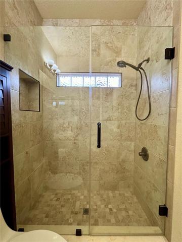 guest walk in shower, transom window, seamless glass door entry