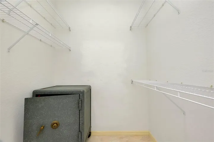Primary His & Her Walk In Closet With Safe