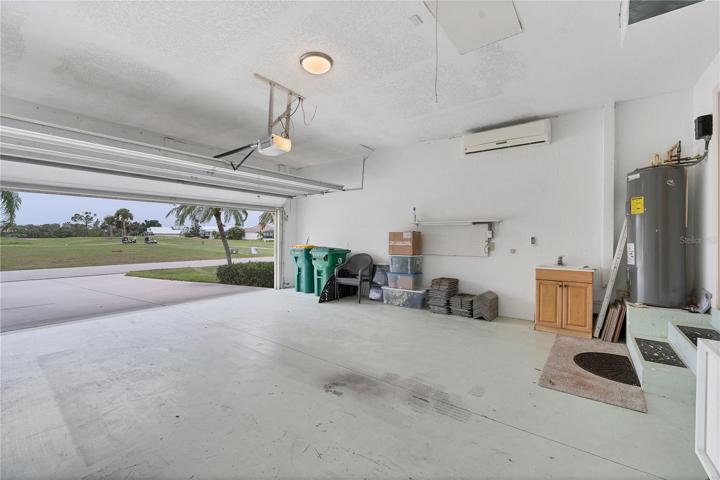 The larger garage has a utility sink, newer HW tank, pull down ladder for attic access and a AC wall unit