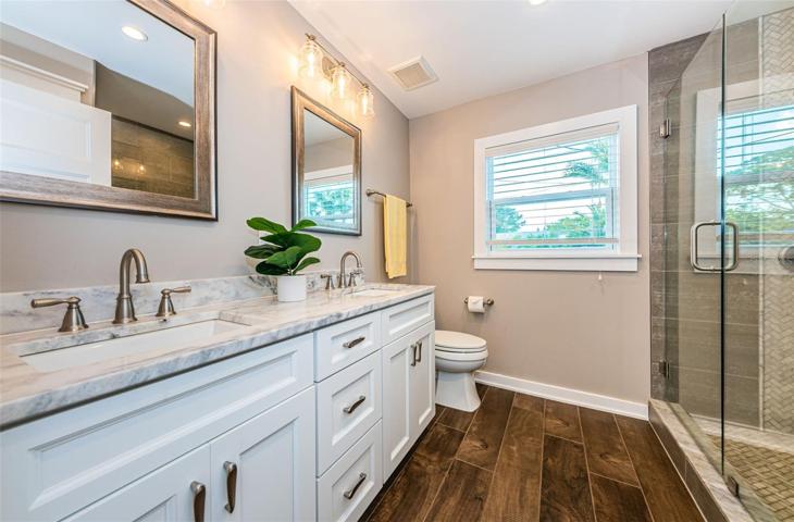 The primary bathroom has double sinks and a frameless glass shower.