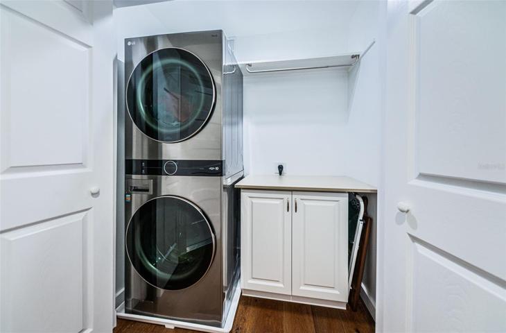 Interior laundry closet with folding counter and hanging rack.