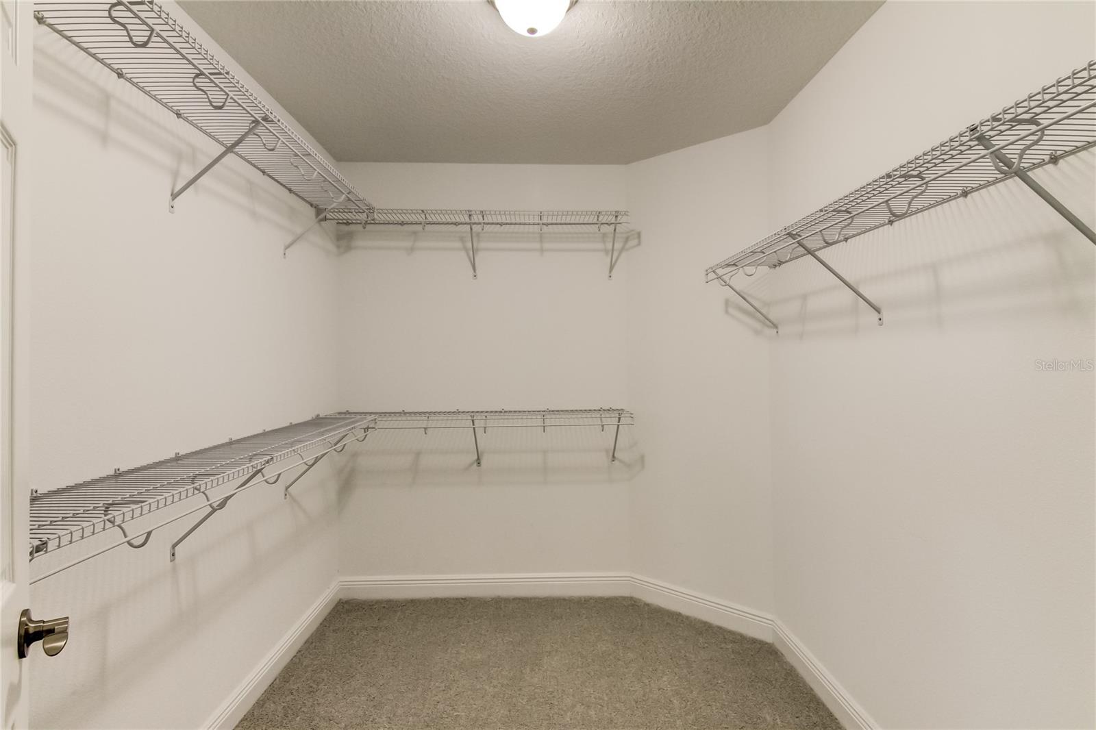 1 of 2 walk-in closets for primary bedroom