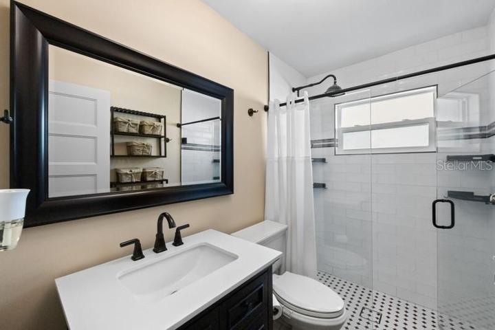 BATHROOOM 1 WITH SEAT HEIGHT COMMODE AND TILED WALK IN SHOWER