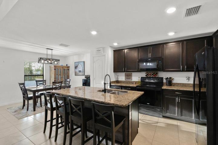 Spacious kitchen featuring ample cabinetry, granite countertops, newer appliances, and a large island with breakfast bar!