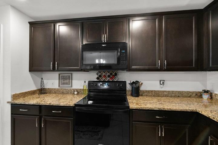 Spacious kitchen featuring ample cabinetry, granite countertops, newer appliances, and a large island with breakfast bar!