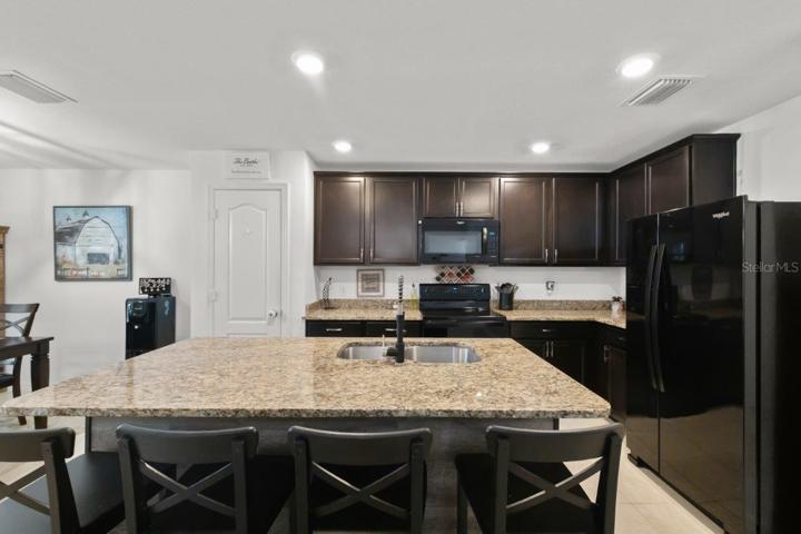 Spacious kitchen featuring ample cabinetry, granite countertops, newer appliances, and a large island with breakfast bar!