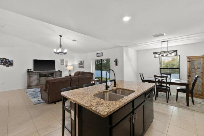 Spacious kitchen featuring ample cabinetry, granite countertops, newer appliances, and a large island with breakfast bar!