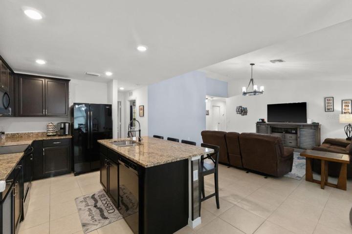 Spacious kitchen featuring ample cabinetry, granite countertops, newer appliances, and a large island with breakfast bar!