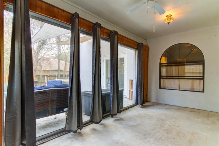 Enclosed bonus room with windows to the main living and slider doors to the patio