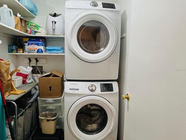 Laundry Room with open shelves and stackable New Washer and Dryer