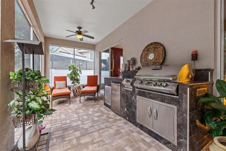 Outdoor gas grill kitchen.  Sliders open up from the family room and primary bedroom