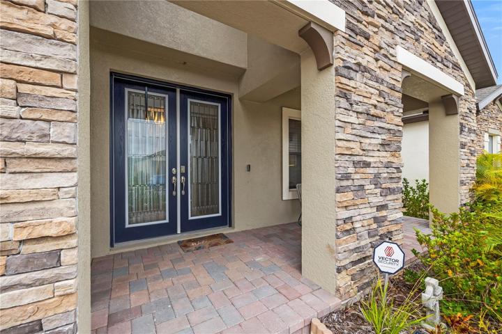 Front entry to home with beautiful double doors and welcoming pavers