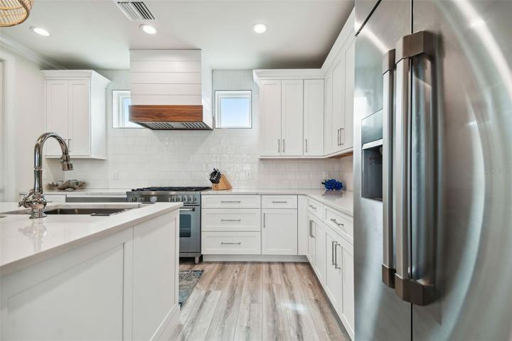 Kitchen with tiled backsplash to ceiling and crown molding.