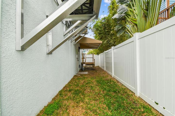 Fenced in side yard/dog run with awning cover, accessible from garage.