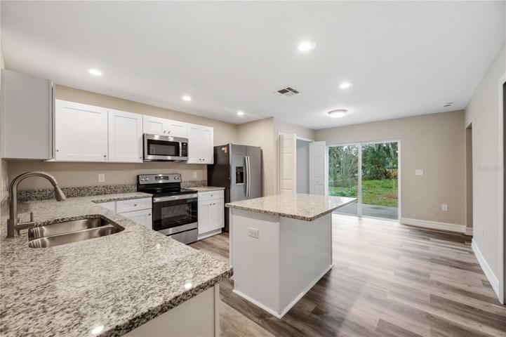 white shaker cabinets, granite counters, stainless steel appliances