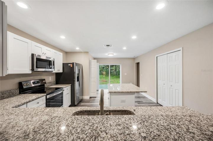 white shaker cabinets, granite counters, stainless steel appliances