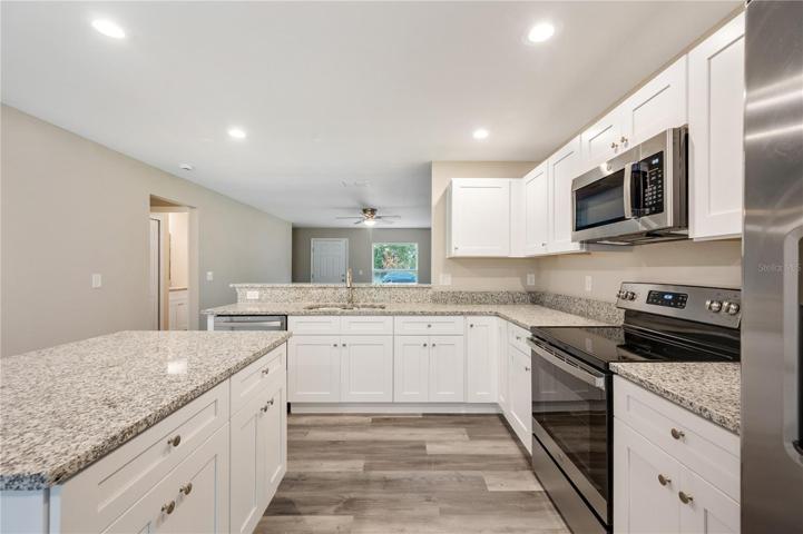 white shaker cabinets, granite counters, stainless steel appliances