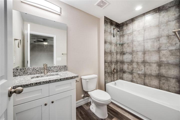 primary bathroom, granite counters, tub/shower combo with tile walls