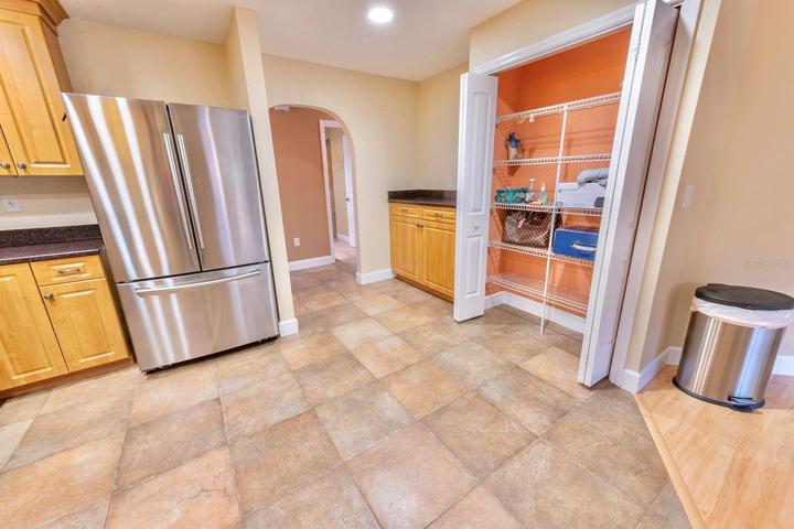 Grand kitchen! Granite, wood cabinets, stainless appliances, bar with extra cabinet storage, double door pantry and room for an island or dinette