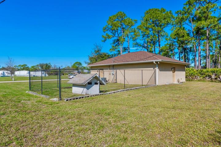Fully fenced dog run with a dog house, also perfect for chickens