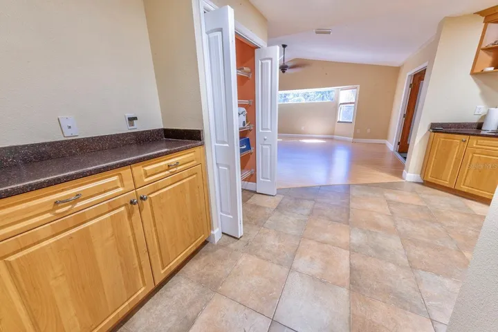 Grand kitchen! Granite, wood cabinets, stainless appliances, bar with extra cabinet storage, double door pantry and room for an island or dinette