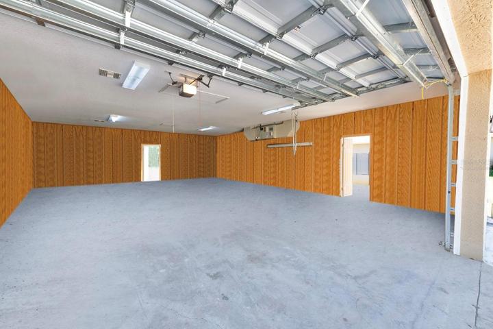 1,200sqft Air Conditioned Garage with side and back doors in addition to the full-sized garage door. Garage has it's own dedicated HVAC system and electrical panel. Ample lighting, ideal for a workshop or can be converted to a living space. Virtually staged so you can see the possibilities on how to make it your own space!