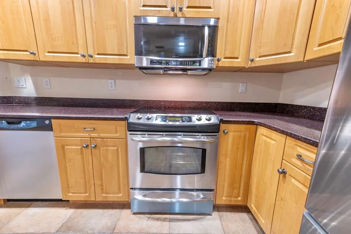 Grand kitchen! Granite, wood cabinets, stainless appliances, bar with extra cabinet storage, double door pantry and room for an island or dinette