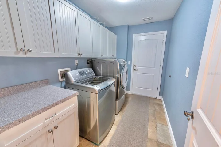 Full laundry room washer/dryer hookup, folding space and ample cabinets for storage