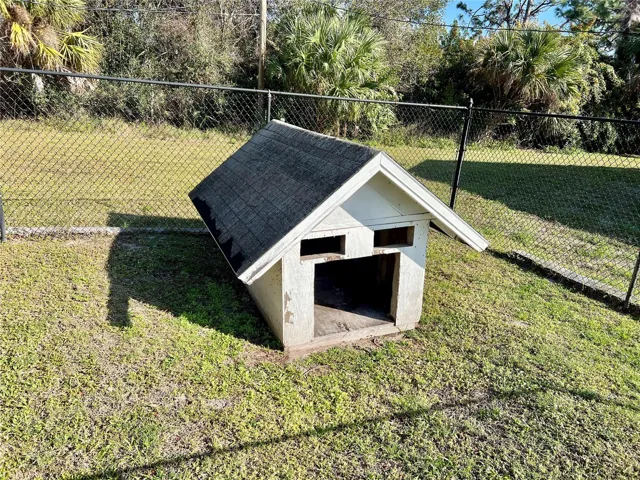Fully fenced dog run with a dog house, also perfect for chickens