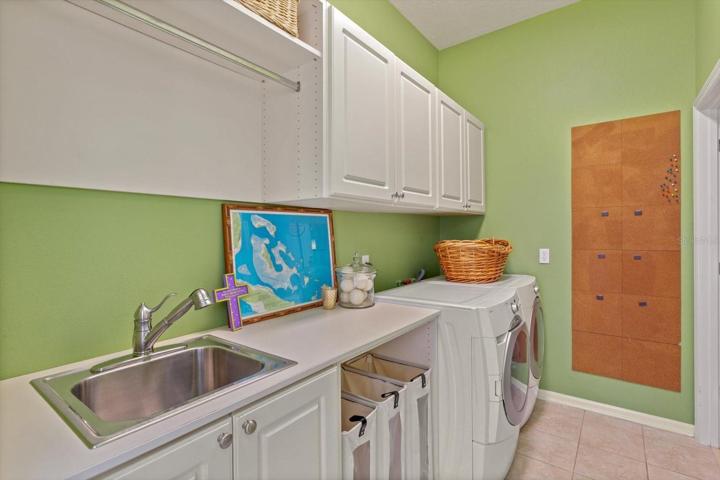Separate laundry room with custom built-ins and  sink