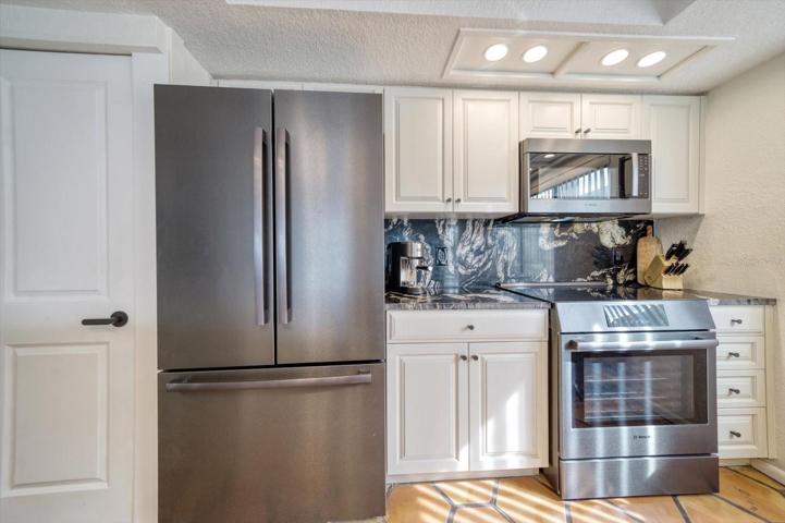 Large pantry, stellar appliances and gleaming granite in kitchen area.