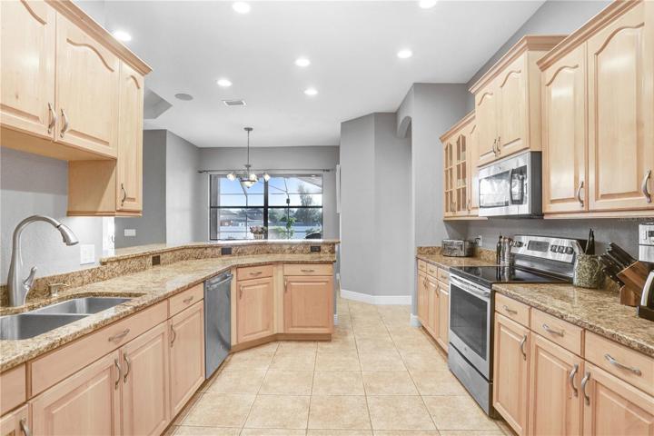 VIEW TO KITCHEN FROM INFRONT OF PANTRY: BREAKFAST BAR, GRANITE COUNTERTOPS
