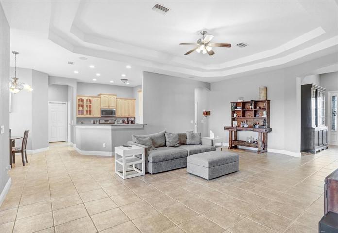 VIEW OF GREAT ROOM TAKEN FROM IN FRONT OF SLIDING GLASS DOORS LEADING TO COVERED/SCREENED IN LANAI/POOL -- , KITCHEN, DINETTE, ENTRANCE : TRAY CEILINGS, W--  ENTRANCE WAY IN THE CENTER LEADS TO BEDROOMS 1 & 2, SHARED BATH & POOL BATH
