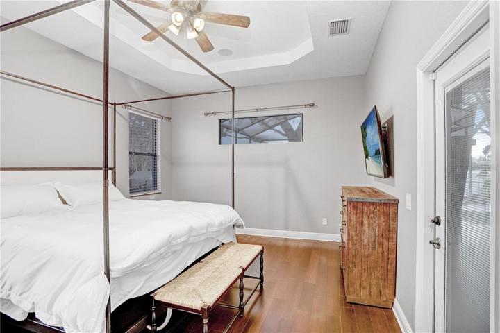 PRIMARY BEDROOM - DOOR ON LEFT LEADS TO 2 WALK-IN CLOSETS & PRIMARY BATH (GARDEN TUB,WALK-IN SHOWER, WC, DOUBLE VANITY -  DOOR ON THE RIGHT LEADS TO THE COVERED/SCREENED-IN LANAI/POOL)