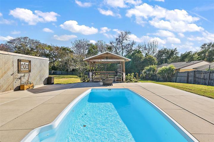 Out the French doors to the pool, deck and fully fenced yard