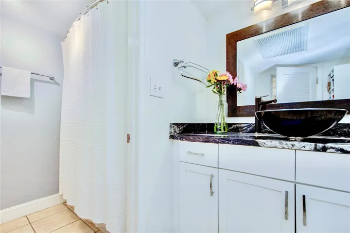 Renovated bathroom with a stunning blue glass vessel sink and granite countertops ..... a tub/shower combo and commode in a separate room for privacy.