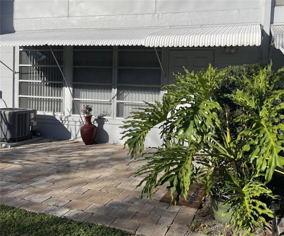 The back yard has pavers and a covered awning.