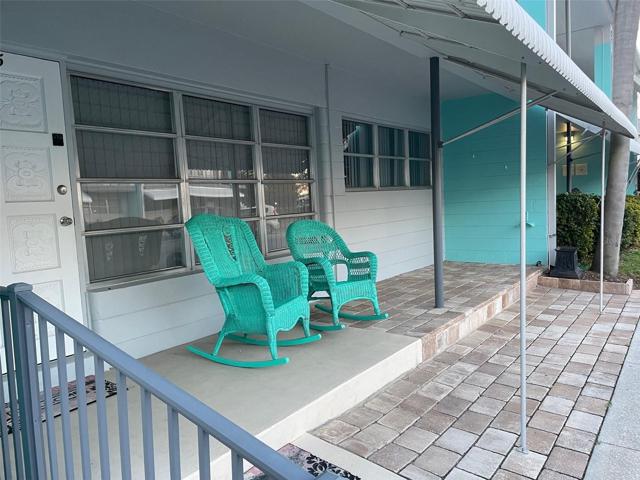 Front porch with paver extensions providing extra seating area and space for potted plants.