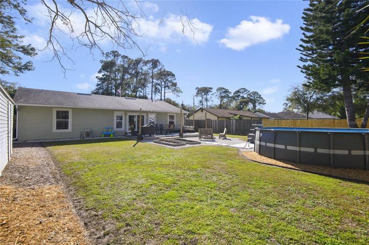 Fenced-in backyard with above ground pool and deck