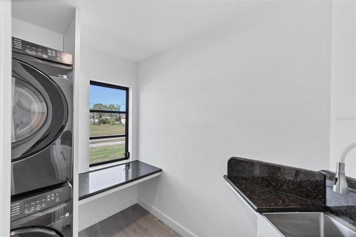 Laundry room with full size washer and dryer and sink.