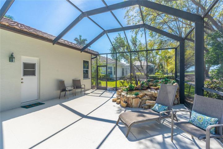 Caged pool deck view of bathroom door, fountain and open space