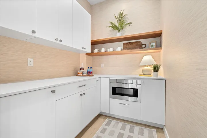 Butler's pantry with prep space, extra  storage, floating shelves and microwave drawer