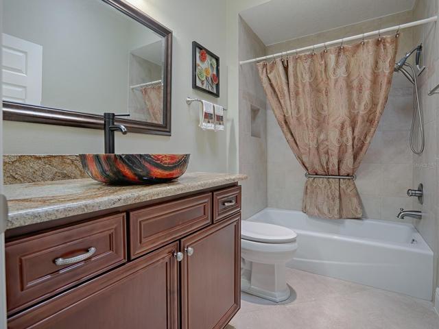 GUEST BATH WITH GRANITE COUNTERS, VESSEL SINK, FRAMED MIRROR, TUB/SHOWER.
