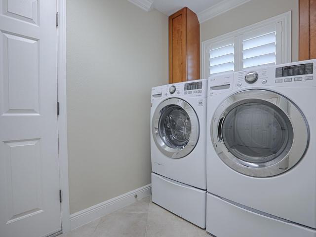 FRONT LOAD WASHER AND DRYER ON PEDESTALS DO CONVEY WITH THE HOME.  ACROSS FROM THIS IS A LARGE DOUBLE DOOR PANTRY CLOSET WITH SHELVING AND PULL-OUT DRAWERS.