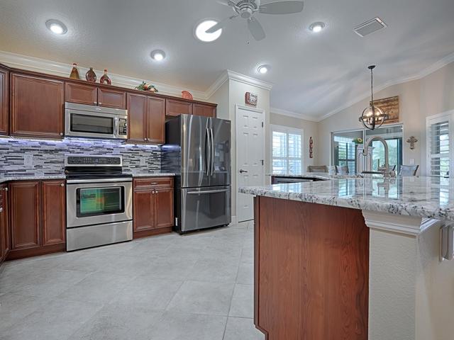 CHERRY CABINETRY WITH OVER AND UNDER CABINET LIGHTING. STAINLESS APPLIANCES AND CLOSET PANTRY.