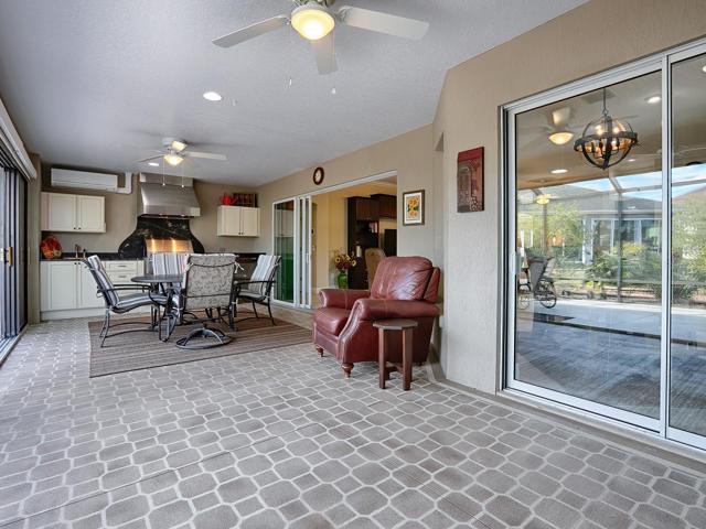 OVERSIZED GLASS ENCLOSED LANAI WITH SUMMER KITCHEN.  PAINTED FLOORING AND NEW CEILING FANS.