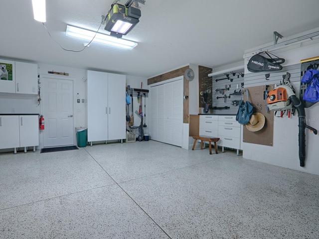 EPOXY PAINTED FLOORING IN THE 2 CAR+ GOLF CART GARAGE. GREAT WORKBENCH TOO WITH LOTS OF EXTRA CABINETS FOR STORAGE.