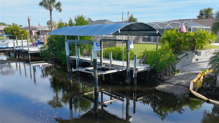 Wide canal with beautiful dock, boat lift and canopy