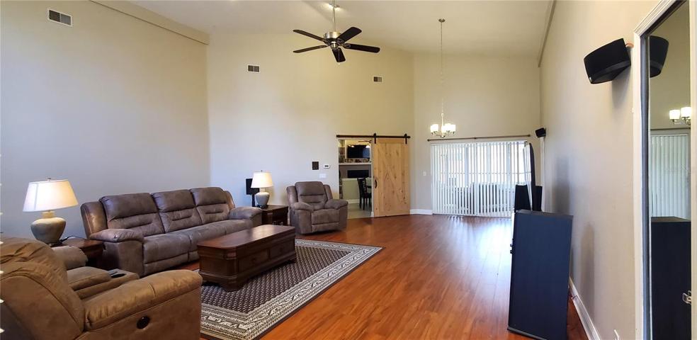 Large living room used as media room, high ceilings.