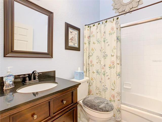 Guest Bath has a tub-shower combination and granite countertop on the sink.